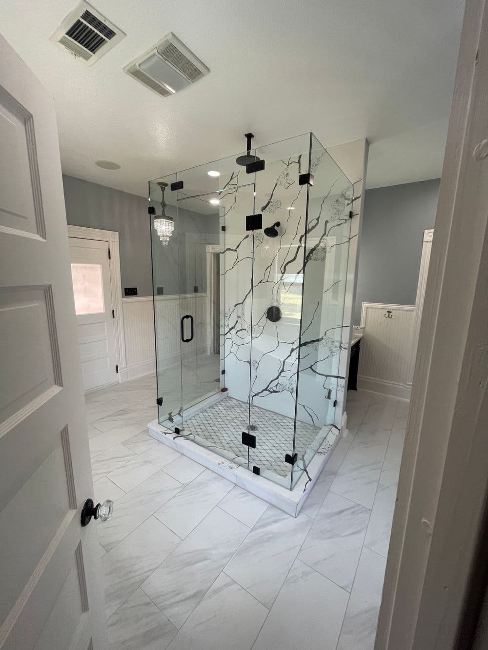 Modern glass shower enclosure with marble accents in a stylish bathroom interior.