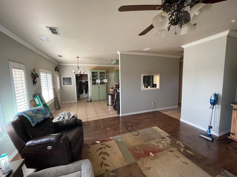 Spacious living room with hardwood floors, ceiling fan, and modern decor.