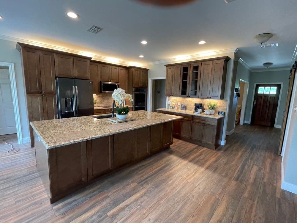 Modern kitchen featuring dark wood cabinetry, granite countertops, and stainless steel appliances.