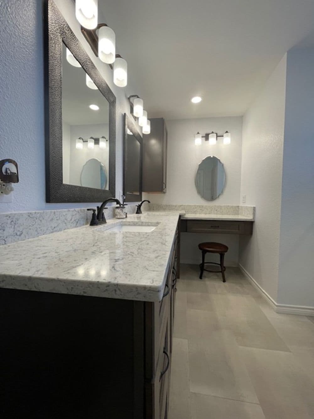 Modern bathroom with double sinks, elegant mirrors, and stylish lighting fixtures.