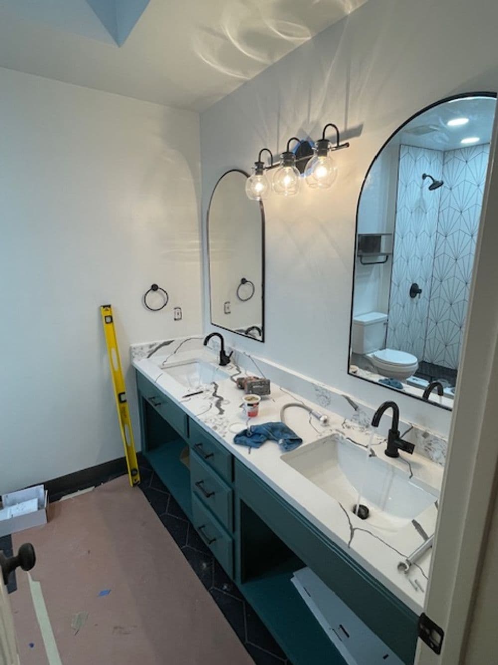 Modern bathroom renovation featuring dual sinks, stylish mirrors, and patterned tile.
